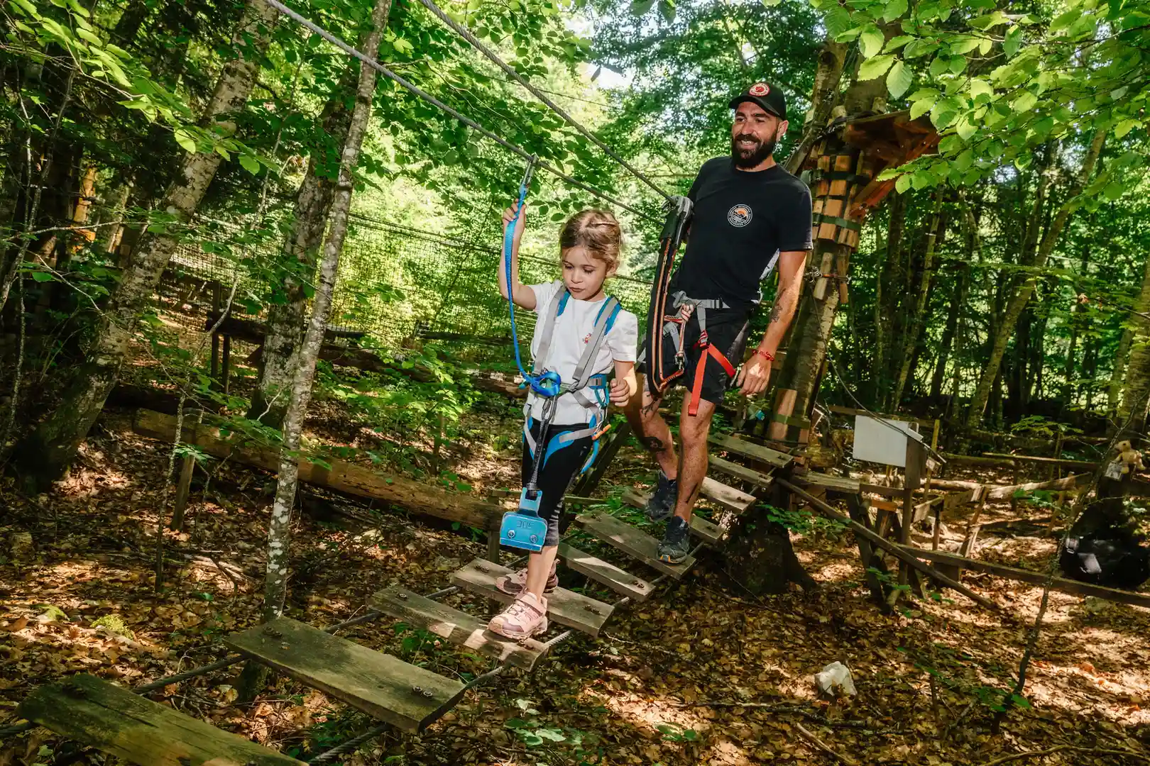 une famille qui fait une passerelle dans les arbres